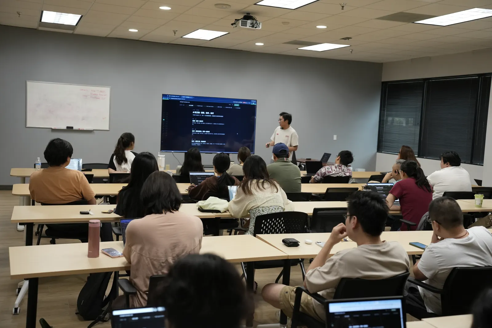A full classroom in Dallas at one of Jack Qian's hands-on AI workshops, Jack presenting at the screen